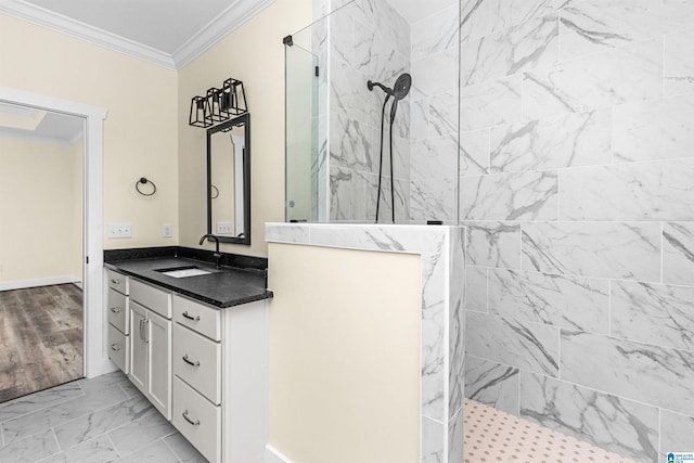 bathroom featuring tiled shower, vanity, hardwood / wood-style flooring, and ornamental molding