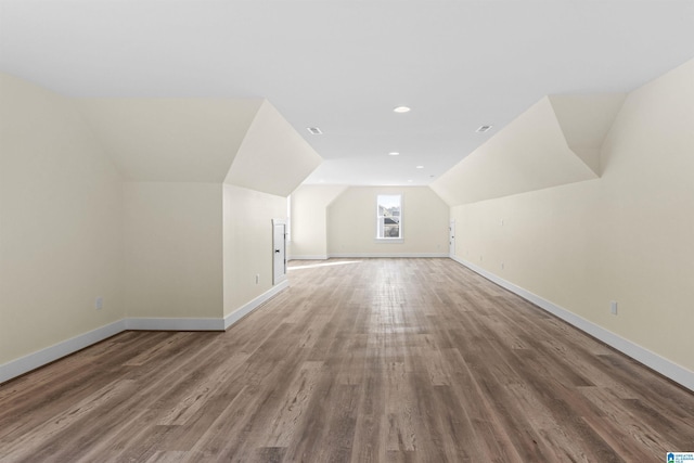 additional living space featuring hardwood / wood-style floors and vaulted ceiling