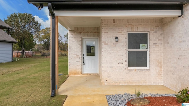 view of exterior entry with a yard