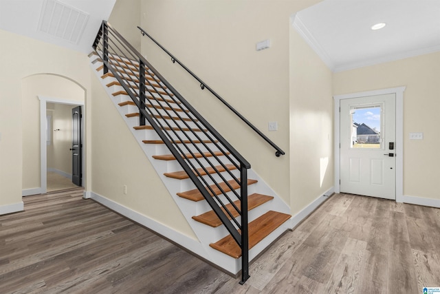 foyer entrance featuring wood-type flooring and crown molding