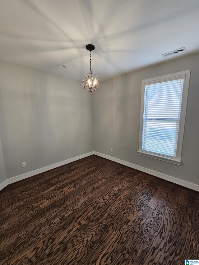 unfurnished room with dark wood-type flooring and an inviting chandelier