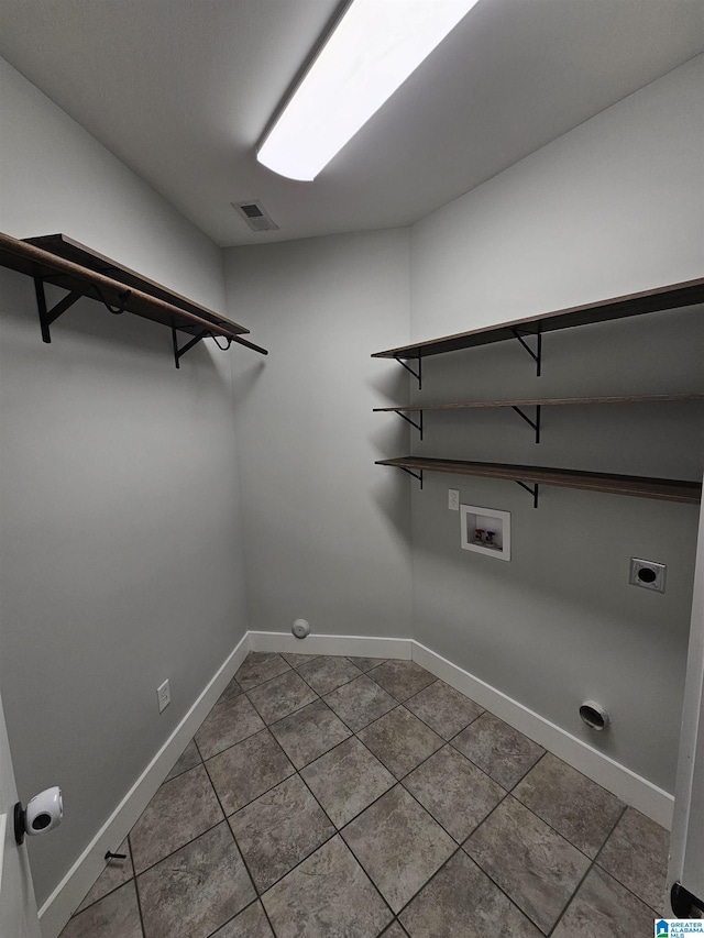 washroom with hookup for an electric dryer, washer hookup, and tile patterned flooring