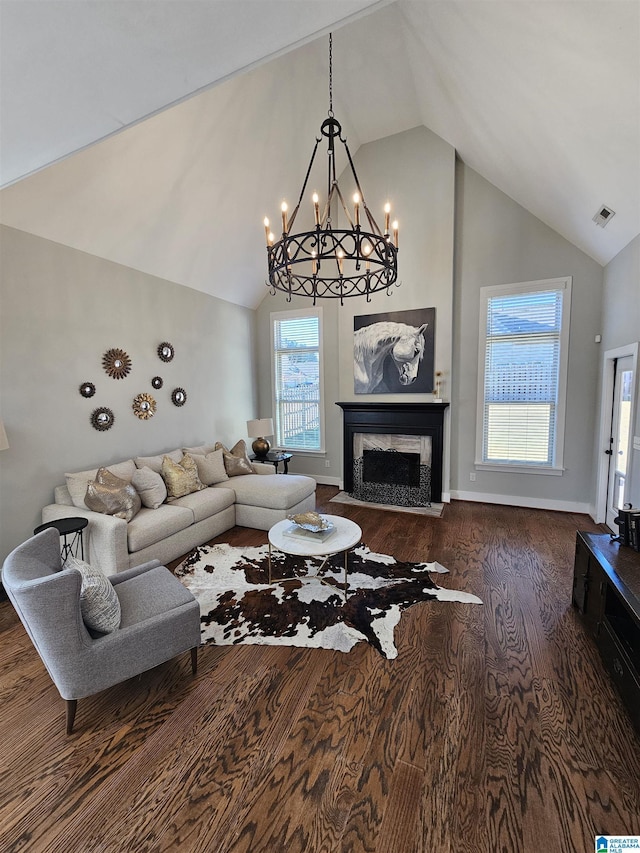 living room with wood-type flooring, high vaulted ceiling, and an inviting chandelier