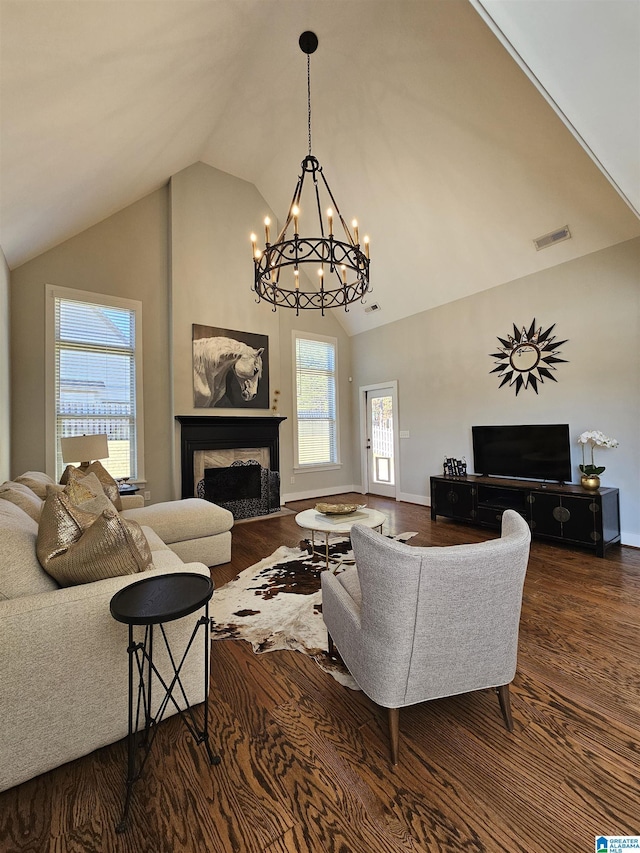 living room with hardwood / wood-style flooring, high vaulted ceiling, and a chandelier