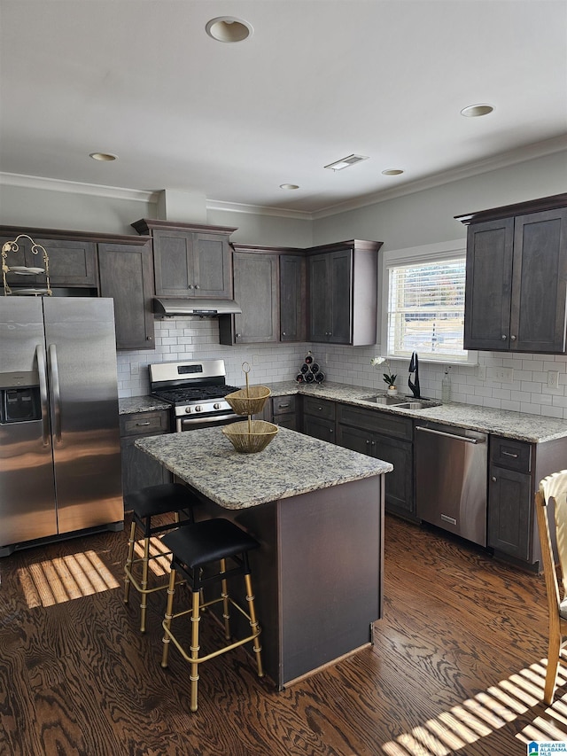 kitchen featuring a center island, sink, dark hardwood / wood-style floors, dark brown cabinetry, and stainless steel appliances