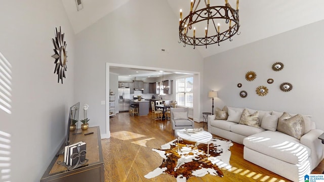 living room with wood-type flooring, high vaulted ceiling, and a notable chandelier