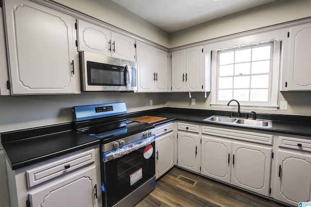 kitchen featuring sink, white cabinets, stainless steel appliances, and dark hardwood / wood-style floors