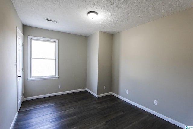 unfurnished room with dark hardwood / wood-style flooring and a textured ceiling