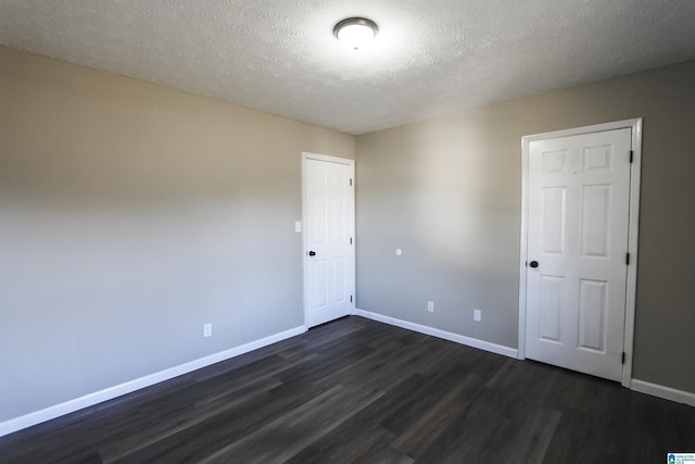 empty room featuring dark wood-type flooring and a textured ceiling