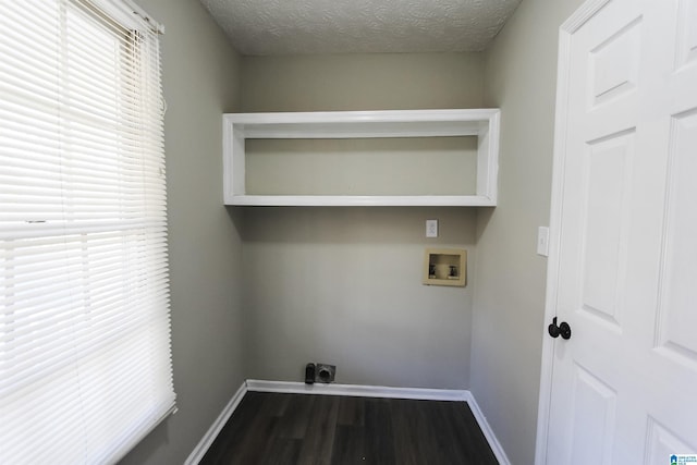 laundry room featuring hookup for an electric dryer, dark hardwood / wood-style floors, a textured ceiling, and hookup for a washing machine