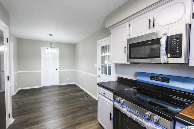 kitchen with an inviting chandelier, hanging light fixtures, dark hardwood / wood-style floors, appliances with stainless steel finishes, and white cabinetry