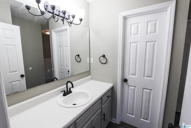 bathroom with a notable chandelier and vanity