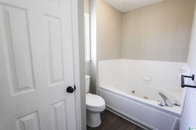 bathroom with a bath, a textured ceiling, hardwood / wood-style flooring, and toilet