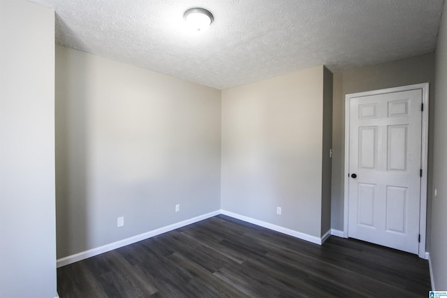 spare room with dark hardwood / wood-style flooring and a textured ceiling