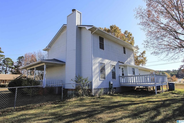 back of house with a lawn and a wooden deck