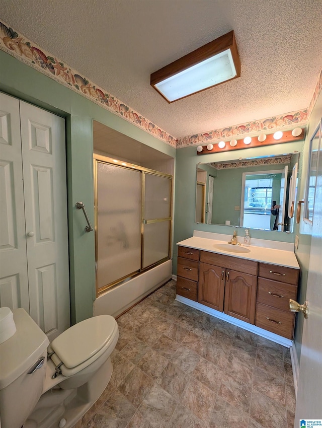 bathroom featuring vanity, toilet, a shower with door, and a textured ceiling