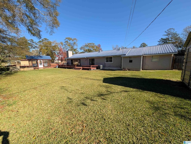 back of property with a lawn and a deck