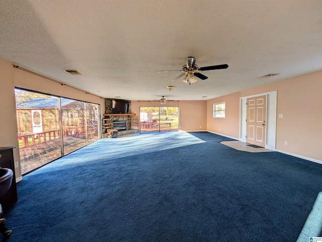 unfurnished living room with ceiling fan, a fireplace, carpet floors, and a textured ceiling