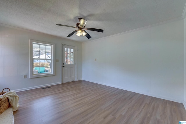 unfurnished room with ceiling fan, light wood-type flooring, a textured ceiling, and ornamental molding