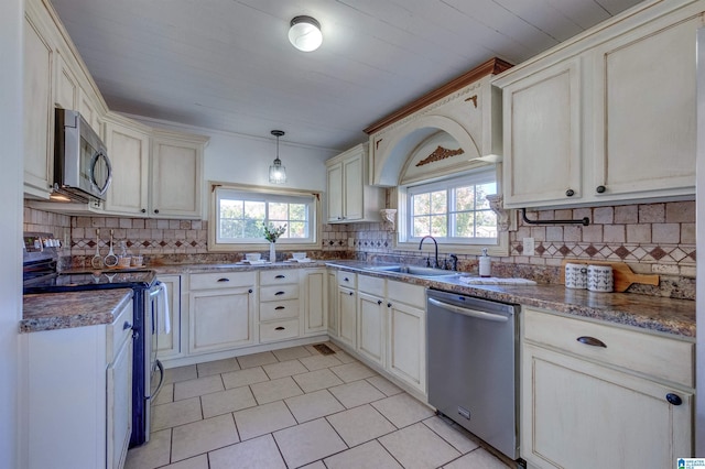 kitchen featuring decorative backsplash, appliances with stainless steel finishes, plenty of natural light, and sink