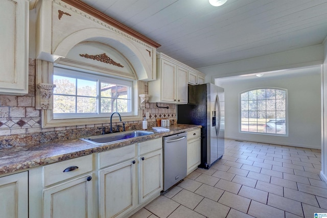 kitchen with sink, wooden ceiling, tasteful backsplash, dark stone countertops, and appliances with stainless steel finishes