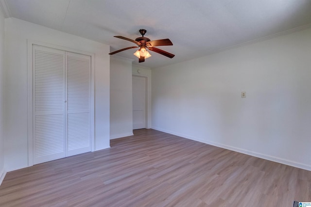 unfurnished bedroom with crown molding, ceiling fan, a closet, and light hardwood / wood-style floors