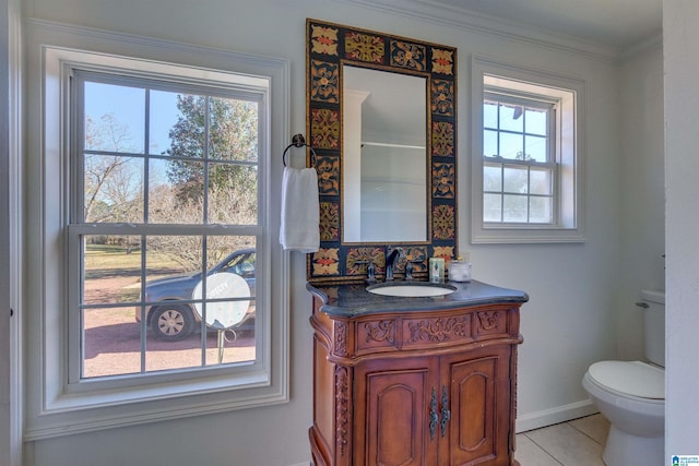 bathroom featuring ornamental molding, vanity, toilet, and a healthy amount of sunlight