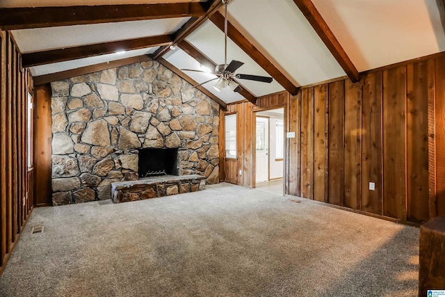 unfurnished living room featuring light carpet, vaulted ceiling with beams, and wooden walls