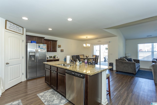 kitchen with dark hardwood / wood-style flooring, stainless steel appliances, a wealth of natural light, and an island with sink