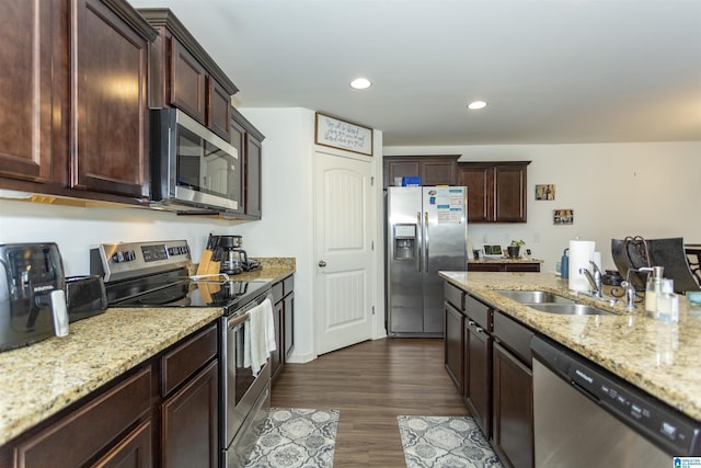 kitchen featuring light stone counters, sink, stainless steel appliances, and dark hardwood / wood-style floors