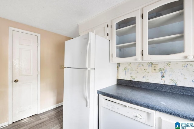 kitchen with white cabinets, a textured ceiling, white appliances, and dark hardwood / wood-style floors