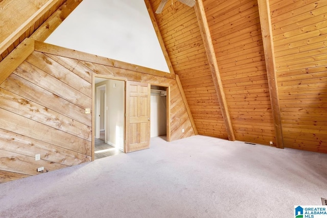 additional living space featuring carpet flooring, vaulted ceiling with beams, wooden ceiling, and wooden walls