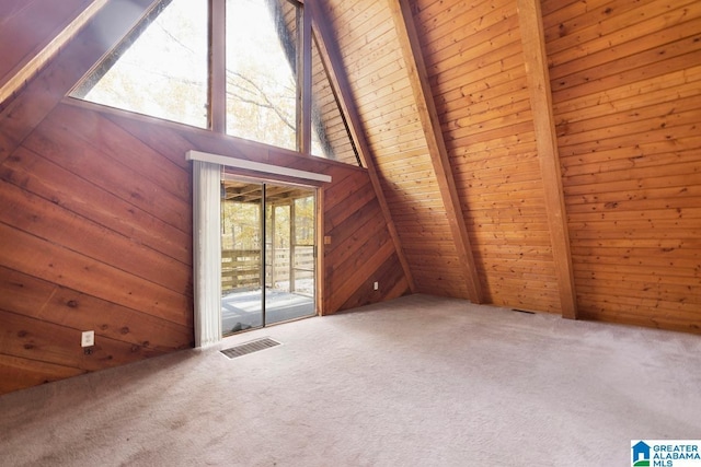 additional living space featuring carpet floors, lofted ceiling with beams, and wood walls