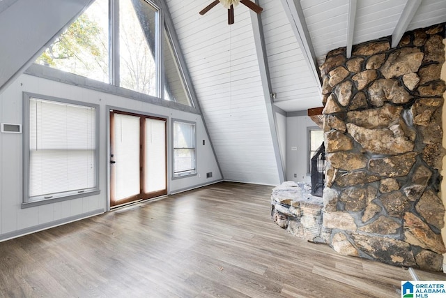 unfurnished living room featuring hardwood / wood-style floors, ceiling fan, beamed ceiling, and high vaulted ceiling