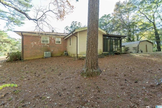 rear view of house featuring central AC and a sunroom