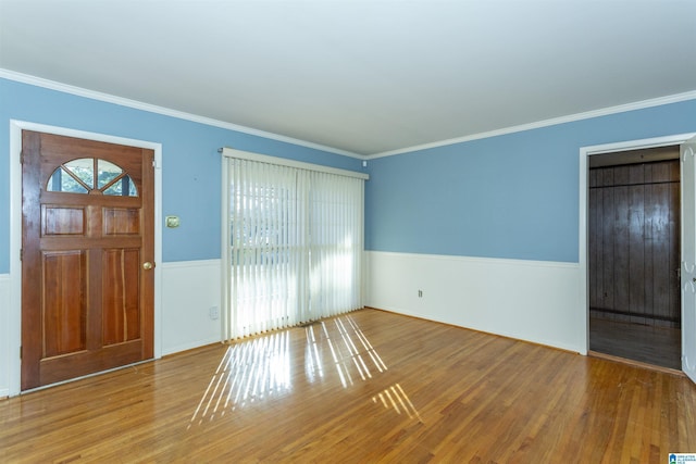 entrance foyer with wood-type flooring, ornamental molding, and a wealth of natural light