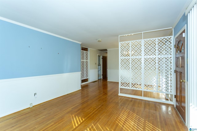 empty room featuring hardwood / wood-style flooring and ornamental molding