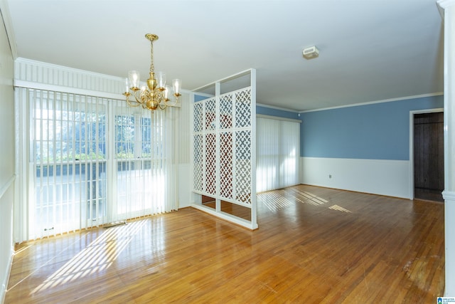 empty room with a chandelier, plenty of natural light, and ornamental molding