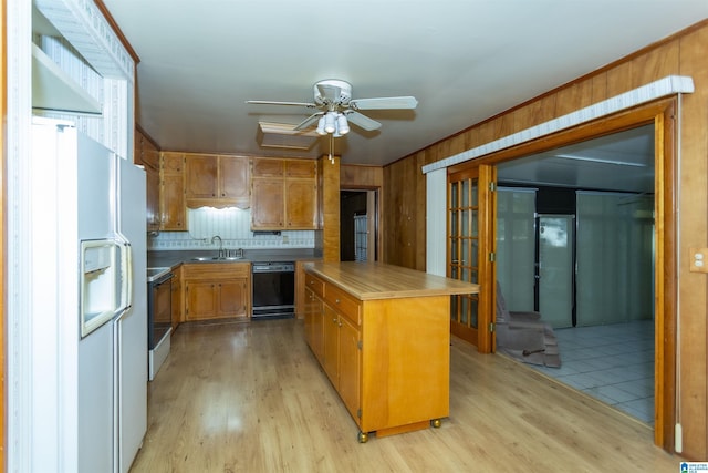 kitchen featuring ceiling fan, sink, white appliances, a kitchen island, and light wood-type flooring