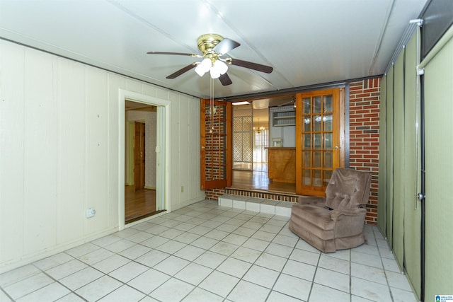 unfurnished room featuring ceiling fan and wood walls