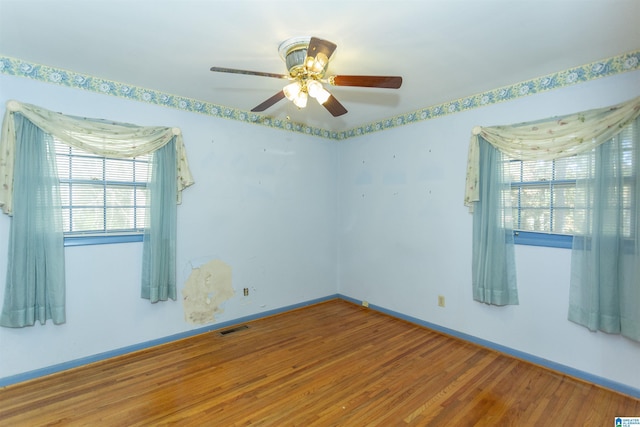 empty room with ceiling fan and hardwood / wood-style flooring