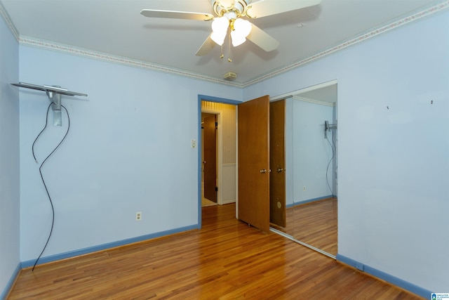 unfurnished bedroom featuring a closet, ceiling fan, hardwood / wood-style floors, and ornamental molding