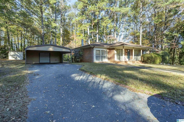 ranch-style home featuring a front yard, a porch, and a carport