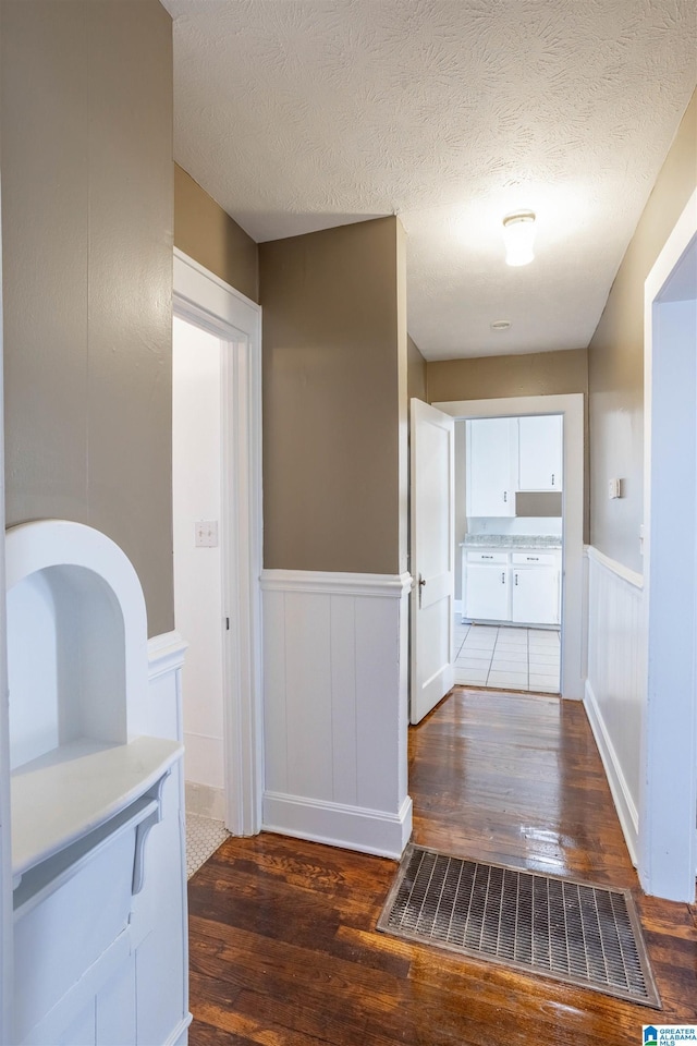 hall featuring dark hardwood / wood-style floors and a textured ceiling