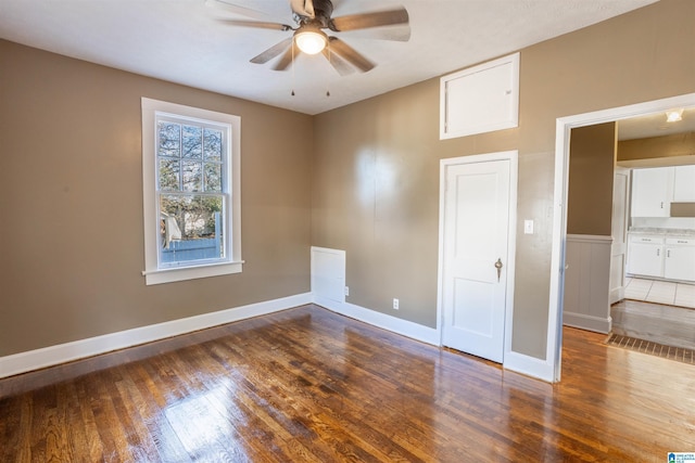 empty room featuring ceiling fan and dark hardwood / wood-style flooring