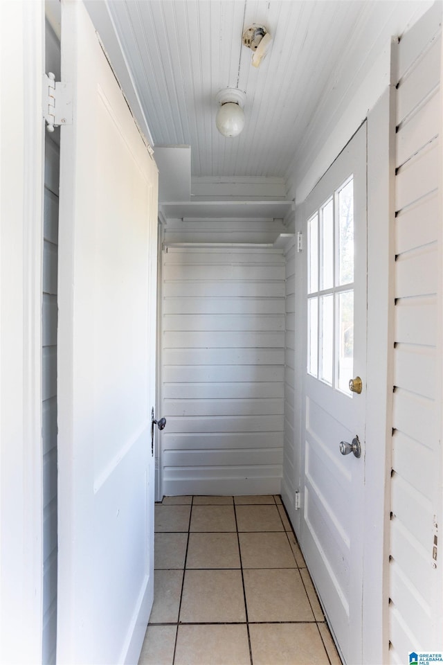 doorway with wood ceiling and light tile patterned flooring