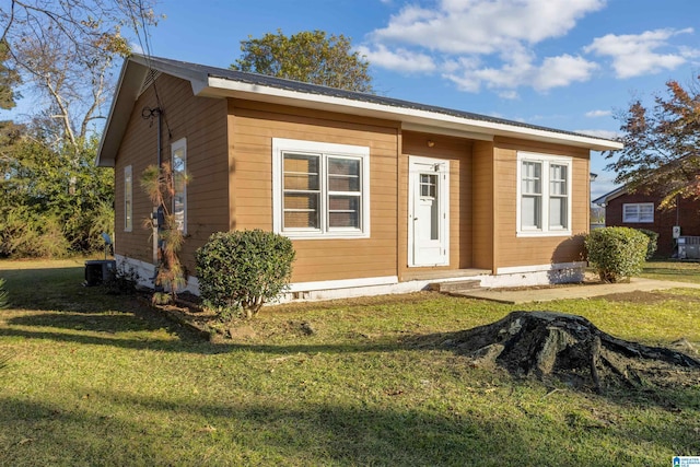 view of front of house with cooling unit and a front yard