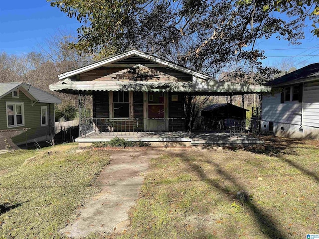 bungalow-style home with a front yard, a porch, and a patio area