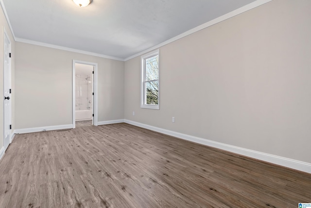 spare room with crown molding and light hardwood / wood-style floors