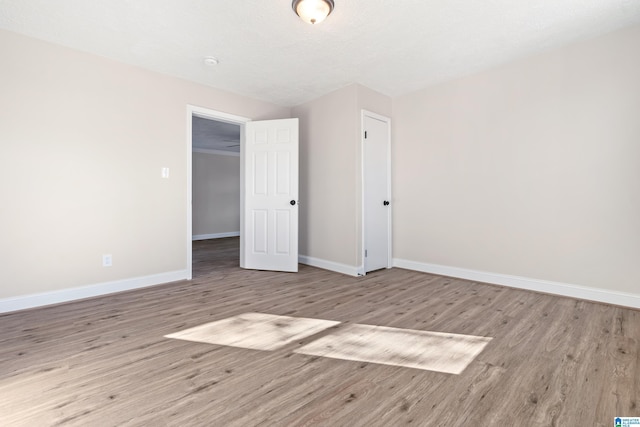 unfurnished bedroom with a textured ceiling and light hardwood / wood-style floors